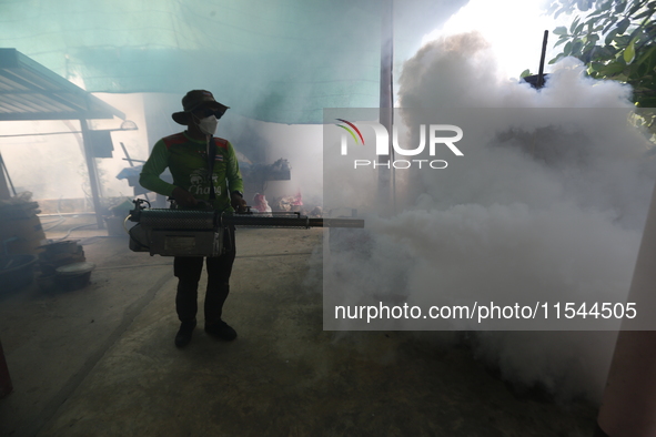 A health worker fumigates to prevent the spread of Dengue fever at a village in Nakhon Sawan province, north of Bangkok, on September 4, 202...