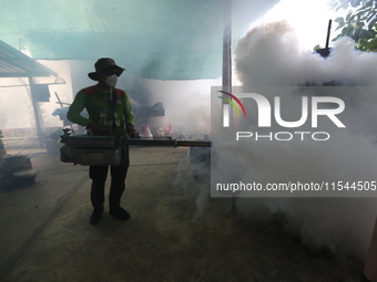 A health worker fumigates to prevent the spread of Dengue fever at a village in Nakhon Sawan province, north of Bangkok, on September 4, 202...