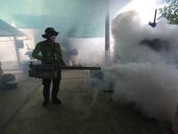 A health worker fumigates to prevent the spread of Dengue fever at a village in Nakhon Sawan province, north of Bangkok, on September 4, 202...