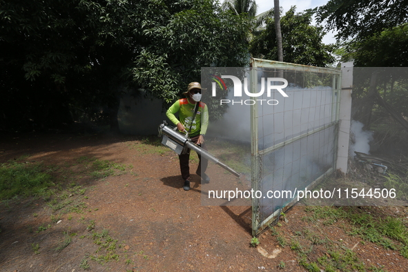 A health worker fumigates to prevent the spread of Dengue fever at a village in Nakhon Sawan province, north of Bangkok, on September 4, 202...