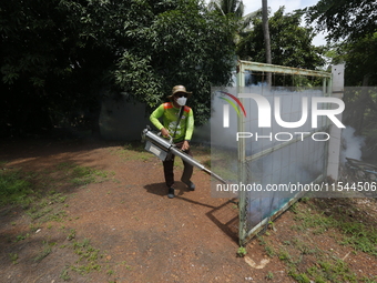 A health worker fumigates to prevent the spread of Dengue fever at a village in Nakhon Sawan province, north of Bangkok, on September 4, 202...