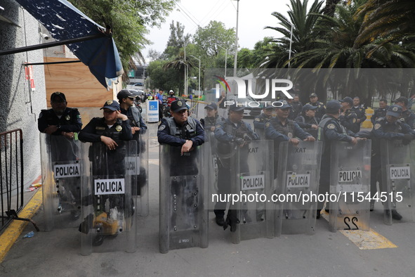 Police guard while law students from different universities join a demonstration outside the Sala de Armas in the Ciudad Deportiva to protes...