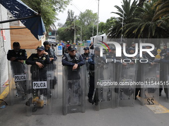 Police guard while law students from different universities join a demonstration outside the Sala de Armas in the Ciudad Deportiva to protes...