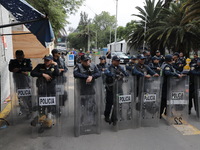 Police guard while law students from different universities join a demonstration outside the Sala de Armas in the Ciudad Deportiva to protes...