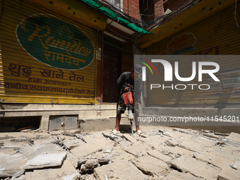 A construction worker drills around the walkways in Kathmandu, Nepal, on August 4, 2024. (