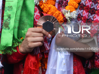 Nepali para athlete and first bronze medalist in Paralympics in Nepal's history, Palesha Goverdhan, poses for a photo along with her medal a...