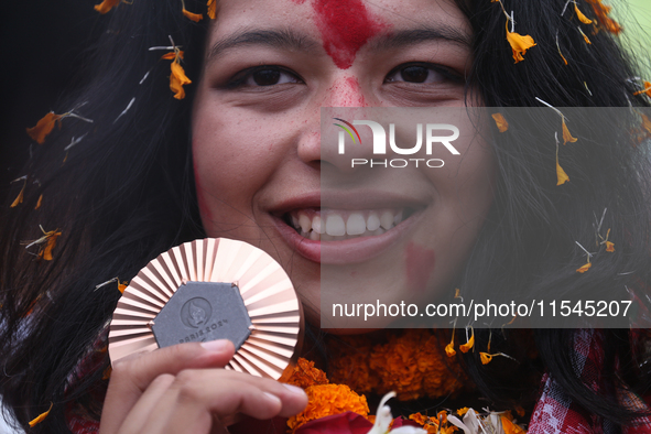 Nepali para athlete and first bronze medalist in Paralympics in Nepal's history, Palesha Goverdhan, poses for a photo along with her medal a...