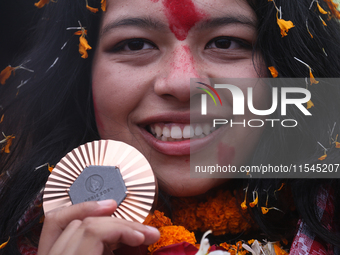 Nepali para athlete and first bronze medalist in Paralympics in Nepal's history, Palesha Goverdhan, poses for a photo along with her medal a...