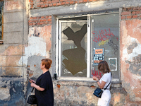 Two women walk past a window broken by the shock wave from the Russian missile attack in the Zaliznychnyi district of Lviv, Ukraine, on Sept...