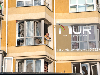 A man stands in the window broken by the shock wave from the Russian missile attack in the Zaliznychnyi district of Lviv, Ukraine, on Septem...