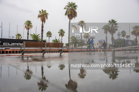 Tourists and locals walk through the city on a rainy September morning in Barcelona, Spain, on September 4, 2024. These first two weeks of S...