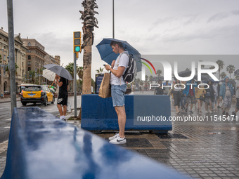 Tourists and locals walk through the city on a rainy September morning in Barcelona, Spain, on September 4, 2024. These first two weeks of S...