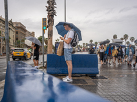 Tourists and locals walk through the city on a rainy September morning in Barcelona, Spain, on September 4, 2024. These first two weeks of S...