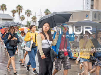 Tourists and locals walk through the city on a rainy September morning in Barcelona, Spain, on September 4, 2024. These first two weeks of S...