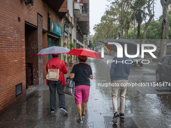 Tourists and locals walk through the city on a rainy September morning in Barcelona, Spain, on September 4, 2024. These first two weeks of S...