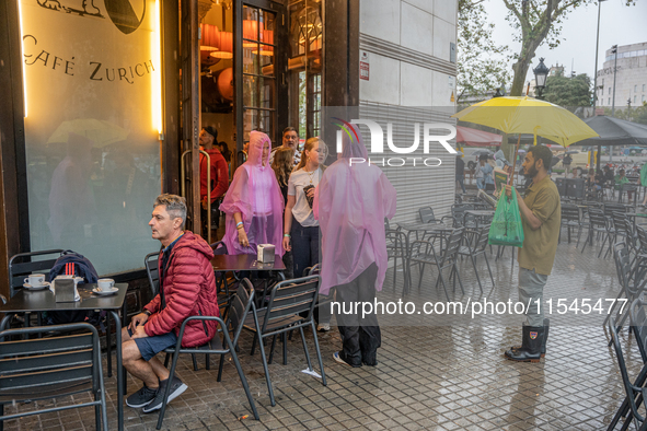 Tourists and locals walk through the city on a rainy September morning in Barcelona, Spain, on September 4, 2024. These first two weeks of S...