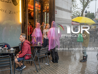 Tourists and locals walk through the city on a rainy September morning in Barcelona, Spain, on September 4, 2024. These first two weeks of S...