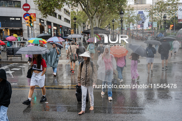 Tourists and locals walk through the city on a rainy September morning in Barcelona, Spain, on September 4, 2024. These first two weeks of S...