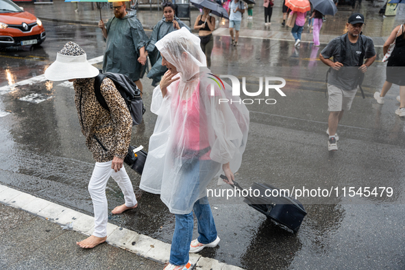 Tourists and locals walk through the city on a rainy September morning in Barcelona, Spain, on September 4, 2024. These first two weeks of S...