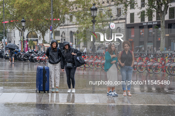 Tourists and locals walk through the city on a rainy September morning in Barcelona, Spain, on September 4, 2024. These first two weeks of S...