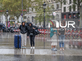 Tourists and locals walk through the city on a rainy September morning in Barcelona, Spain, on September 4, 2024. These first two weeks of S...