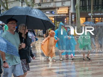 Tourists and locals walk through the city on a rainy September morning in Barcelona, Spain, on September 4, 2024. These first two weeks of S...