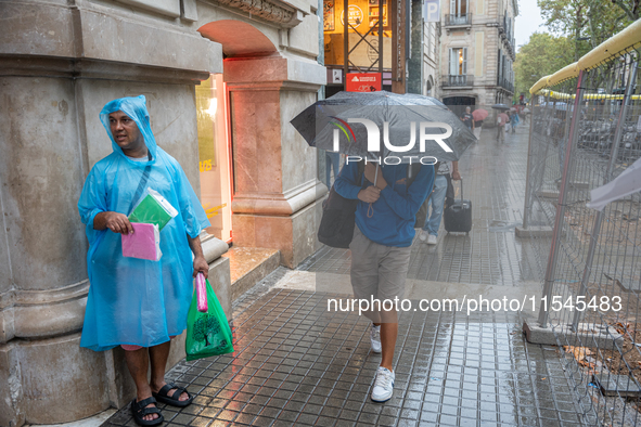 Tourists and locals walk through the city on a rainy September morning in Barcelona, Spain, on September 4, 2024. These first two weeks of S...