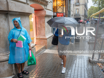 Tourists and locals walk through the city on a rainy September morning in Barcelona, Spain, on September 4, 2024. These first two weeks of S...