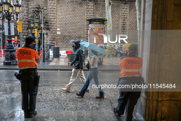 Tourists and locals walk through the city on a rainy September morning in Barcelona, Spain, on September 4, 2024. These first two weeks of S...