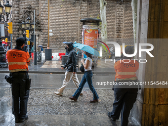 Tourists and locals walk through the city on a rainy September morning in Barcelona, Spain, on September 4, 2024. These first two weeks of S...