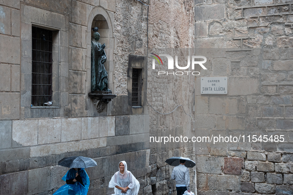 Tourists and locals walk through the city on a rainy September morning in Barcelona, Spain, on September 4, 2024. These first two weeks of S...