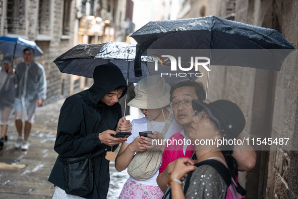 Tourists and locals walk through the city on a rainy September morning in Barcelona, Spain, on September 4, 2024. These first two weeks of S...