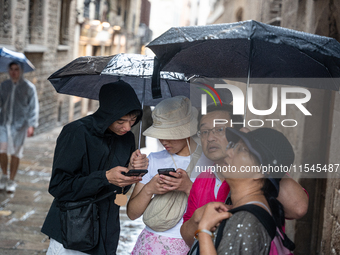 Tourists and locals walk through the city on a rainy September morning in Barcelona, Spain, on September 4, 2024. These first two weeks of S...