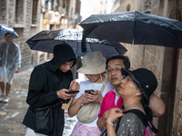 Tourists and locals walk through the city on a rainy September morning in Barcelona, Spain, on September 4, 2024. These first two weeks of S...