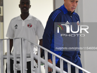 Qatar national team head coach Marquez Lopez (R) and player Moez Al Ali (L) arrive for the press conference at Ahmad Bin Ali Stadium in Al R...