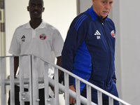 Qatar national team head coach Marquez Lopez (R) and player Moez Al Ali (L) arrive for the press conference at Ahmad Bin Ali Stadium in Al R...