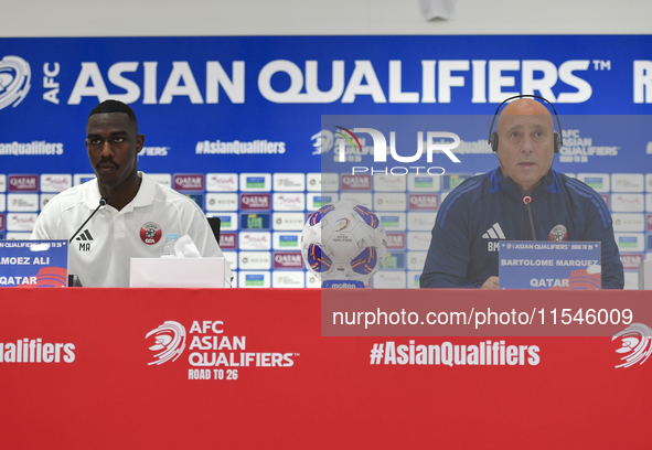 Qatar national team head coach Marquez Lopez (R) and player Moez Al Ali (L) attend a press conference at Ahmad Bin Ali Stadium in Al Rayyan,...