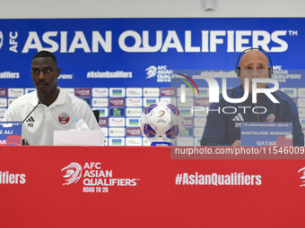 Qatar national team head coach Marquez Lopez (R) and player Moez Al Ali (L) attend a press conference at Ahmad Bin Ali Stadium in Al Rayyan,...