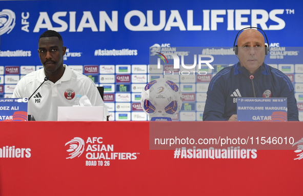 Qatar national team head coach Marquez Lopez (R) and player Moez Al Ali (L) attend a press conference at Ahmad Bin Ali Stadium in Al Rayyan,...