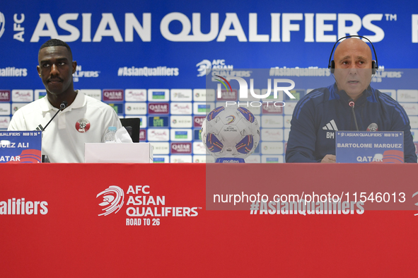 Qatar national team head coach Marquez Lopez (R) and player Moez Al Ali (L) attend a press conference at Ahmad Bin Ali Stadium in Al Rayyan,...