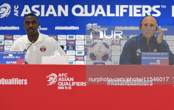 Qatar national team head coach Marquez Lopez (R) and player Moez Al Ali (L) attend a press conference at Ahmad Bin Ali Stadium in Al Rayyan,...