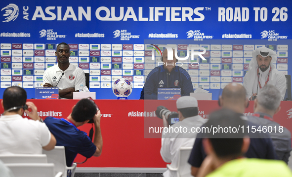 Qatar national team head coach Marquez Lopez (C) and player Moez Al Ali (L) attend a press conference at Ahmad Bin Ali Stadium in Al Rayyan,...