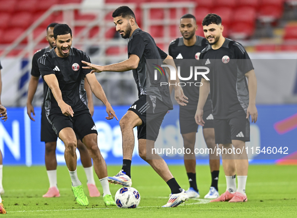 Mohammad Waad (C), Sultan Al Brake (L), and Bassam Al Rawi (R) from the Qatar National football team attend a training session at Ahmad Bin...