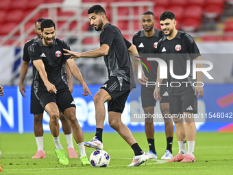 Mohammad Waad (C), Sultan Al Brake (L), and Bassam Al Rawi (R) from the Qatar National football team attend a training session at Ahmad Bin...