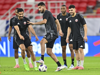 Mohammad Waad (C), Sultan Al Brake (L), and Bassam Al Rawi (R) from the Qatar National football team attend a training session at Ahmad Bin...