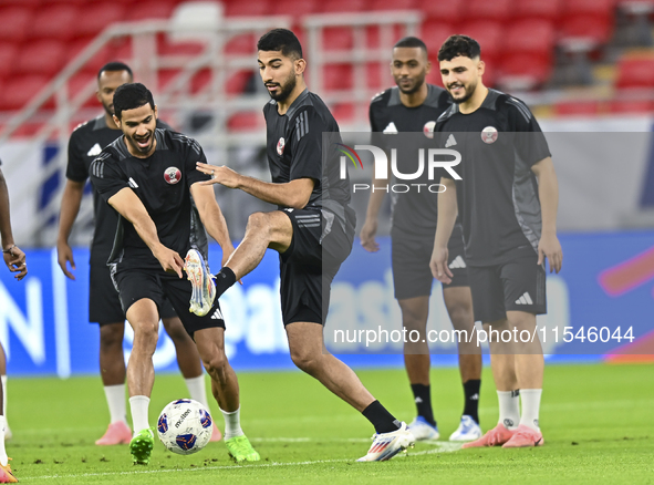 Mohammad Waad (C), Sultan Al Brake (L), and Bassam Al Rawi (R) from the Qatar National football team attend a training session at Ahmad Bin...