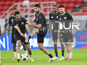 Mohammad Waad (C), Sultan Al Brake (L), and Bassam Al Rawi (R) from the Qatar National football team attend a training session at Ahmad Bin...