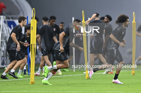 Akram Afif (R) and Pedro Miguel (C) from the Qatar National football team attend a training session at Ahmad Bin Ali Stadium in Al Rayyan, Q...