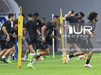 Akram Afif (R) and Pedro Miguel (C) from the Qatar National football team attend a training session at Ahmad Bin Ali Stadium in Al Rayyan, Q...