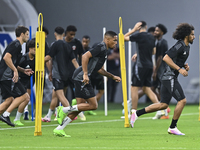 Akram Afif (R) and Pedro Miguel (C) from the Qatar National football team attend a training session at Ahmad Bin Ali Stadium in Al Rayyan, Q...